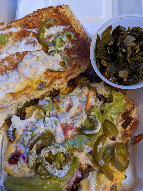 Tasty, filling "da divisadero Aka Not Yo Cheesesteak" loaded sandwich, with a side of collard greens at Vegan Mob in Oakland