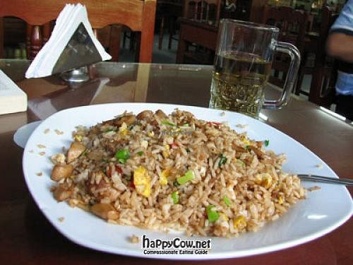 half-eaten plate of 'arroz chaufa' (Chinese-style rice) with mushrooms. Beverage (not beer) in background. at El Paraiso Restaurant Vegetariano  in Pucallpa