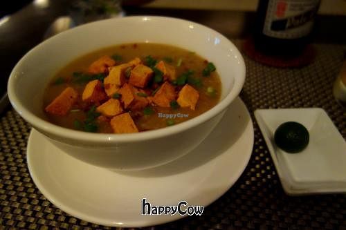 Vegan Arroz Caldo - A big bowl of Filipino rice porridge with shiitake mushrooms topped with fried tofu, crispy garlic and spring onions. at Corner Tree Cafe in Makati