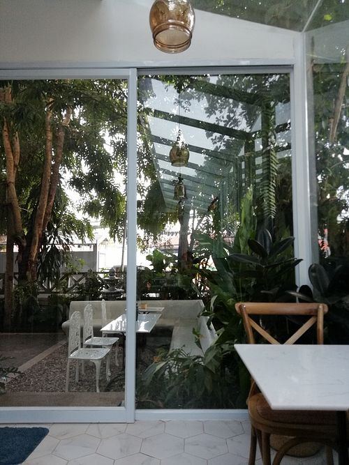 Air-conditioned inside looking at the greeny terrasse at The Living Library in Vientiane