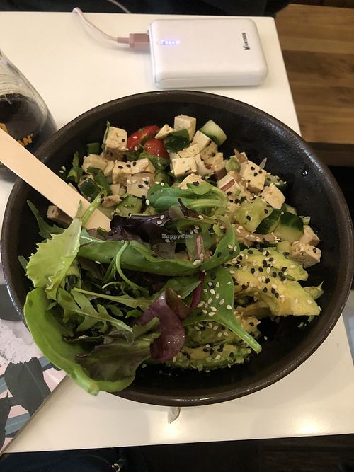 Build your own bowl with: sushi rice, tofu, cucumbers, cilantro, tomatoes, spring onions, crazy lime dressing & avocado. They put sesame seeds and arugula on all bowls.   at Ma'loa in Berlin