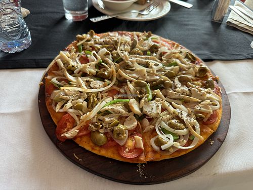 Undercooked custom vegan pizza with raw onions, mushrooms, peppers, olives on a regular crust dough 😟I got really sick that night   at Bliss in Freetown