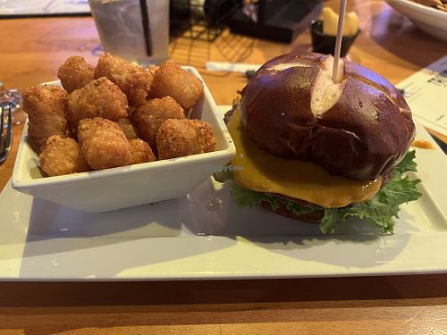 Impossible burger with vegan muenster cheese added and tater tots as a side  at Hoptinger Beer Garden - Riverside in Jacksonville