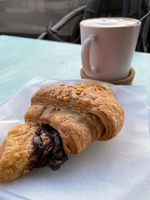 Chocolate and peanuts croissant with a soy and coffee drink at Moko Veggie Café - Alvalade in Lisbon
