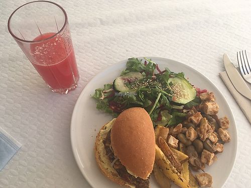 Watermelon juice and plate with half and half of the dishes of the day : tofu and fava beans, vegan burger with potatoes at Granos Espaço Vegetariano in Lisbon