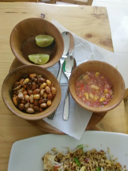 Condiment plate: corn kernels, lime wedges, hot sauce at La Casita de Kawsay in Lima