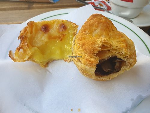 Bitten into nata dessert and mushroom pastry at Confeitaria Tupi in Porto