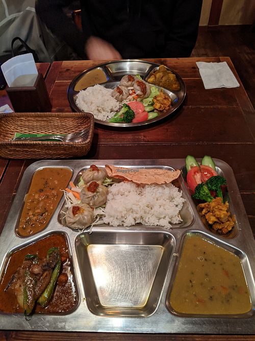 Top: dal bhat set (1 curry - potato) bottom: maitiighar set (2 curries - vegetable / lentil)
Both with veggie Momo, lentil soup and curried potato at Maitiighar Nepali in Fukuoka