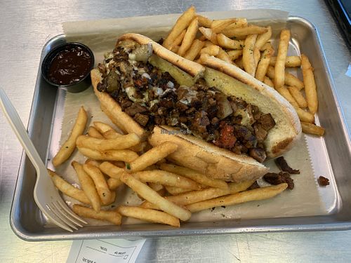 Vegan Philly cheesesteak sandwich with fries  at The Rabbit Hole in Pompano Beach