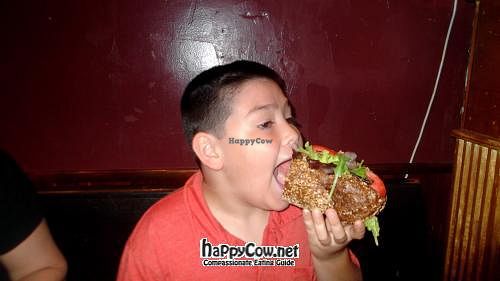 My son trying to navigate the HUGE Philly cheese-fake (vegan version) at Liquid Earth in Baltimore
