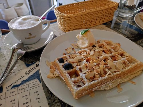 Cappucino with oat milk and vegan marcipan waffle eith Amaretto and vegan vanilla ice cream at Kleines Waffelhaus in Luebeck