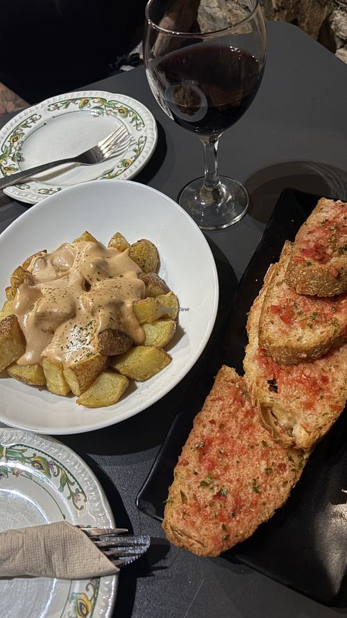 Pan con tomate, patatas bravas y vino autóctono   at L'alfil in Ainsa