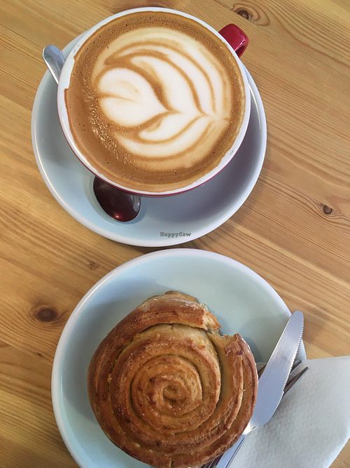 Latte with oat milk and vegan lemon roll at Malabarista Cafe in Lisbon