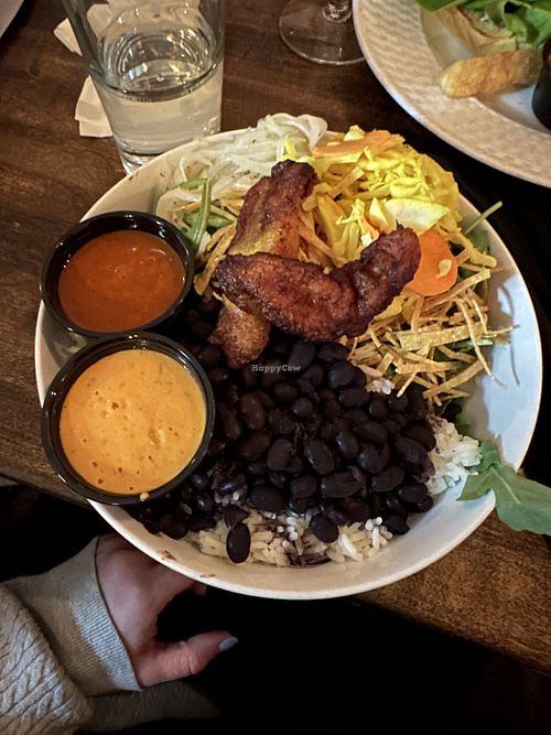Pow pow pow bowl with curtido, spicy white onions, tortilla strips, and maduros. Side of al pastor sauce and sunflower chipotle sauce.  at Hermanas Kitchen and Cocktails in Lindenhurst