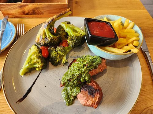 Vegan steak with charred broccoli and fries at Aarmühle in Interlaken