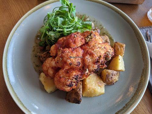 Vegan cauliflower steak, garlic roast potatoes and bean stew (hiding under the leaves!) at The Dunvegan in Isle Of Skye