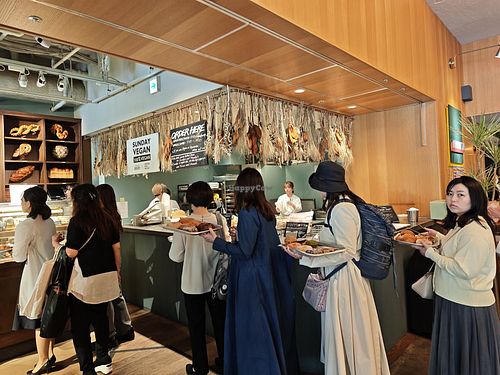 Queue to pay after choosing your stuff and put it in the tray at Morethan Bakery in Tokyo
