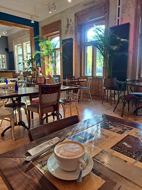Oat latte and interior at The Garden Cafe & Restaurant in Budapest