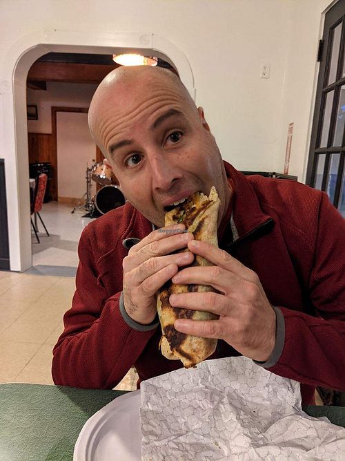 Husband devouring VGF falafelrrito at Veggie Oasis in Shokan