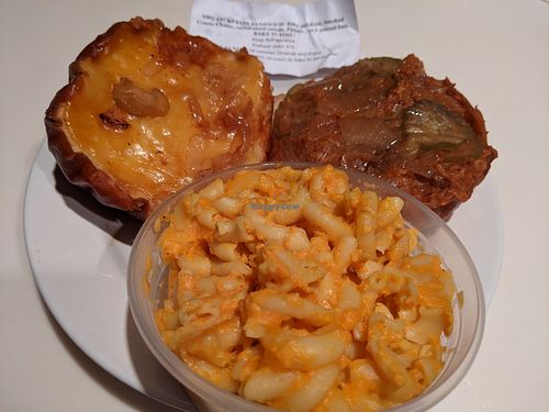 BarBQ jackfruit, carmelized onions, smoked gouda cheese on a pretzel bun with a side of creamy mac and cheese. at Sinfull Bakery in Houston