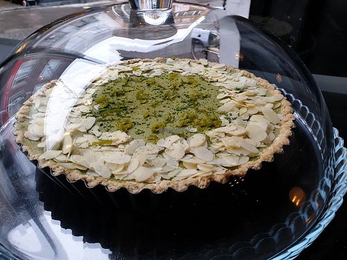 Rich, creamy vegan matcha lime tart topped with almonds in almond crust at We Love Coffee in Leuven
