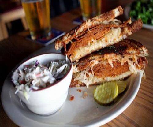 the reubender: house-made vegan pastrami with russian dressing, smoky provolone cheez, sauce and sauerkraut on grilled rye. with a side of coleslaw at Highline Bar in Seattle