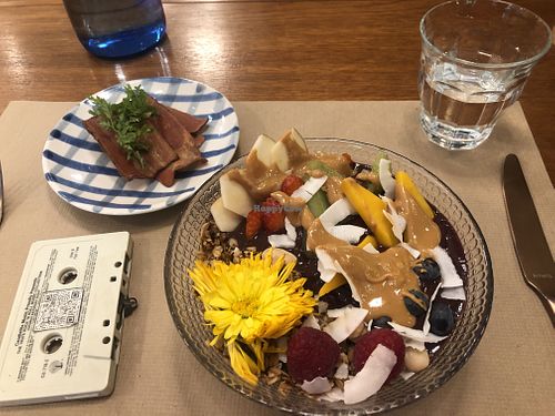 Açaí bowl with peanut butter topping, vegan bacon and a cassette deck with a QR code for the menu! Fits with the 80’s music playing and a retro vibe decor   at Faire Brunch & Drinks in Barcelona