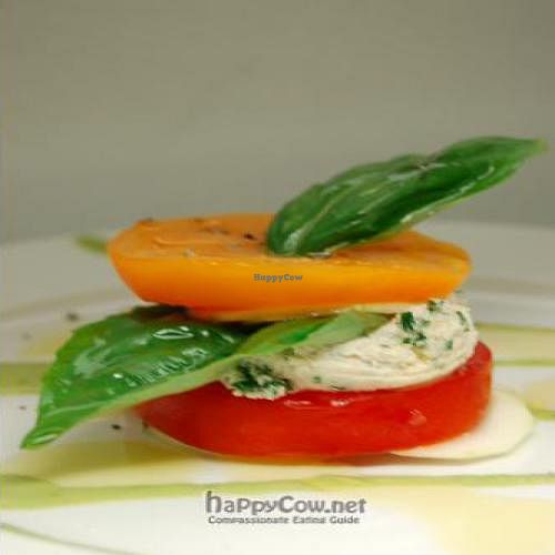 Third Course - Heirloom Tomatoes layered with thinly sliced Zucchini, Almond Cheese, Basil, drizzled with extra virgin olive oil and a rich basil oil at Karma in Northampton