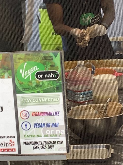 Signage promoting social media accounts and phone number contact at Vegan or Nah in Redlands
