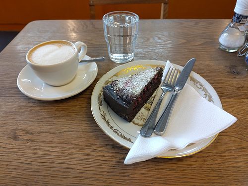 Small cappuccino with oatmilk and vegan fruit-berries-chocolate cake. at De Bakkerswinkel - Kahvalti in Amsterdam