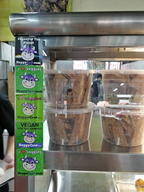 Different generations of HappyCow stickers. at Lotus Seed 莲子素 in West Singapore