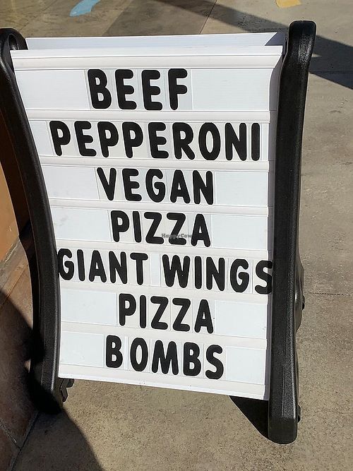 Rolling sign promoting vegan pizza at University Pizza Company in Riverside