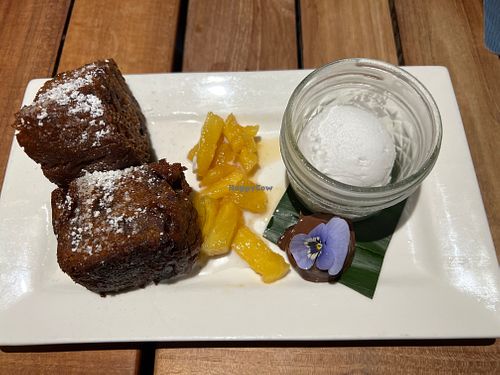 Slightly crisp crusty banana cake in cream, caramelized pineapple, a superrich little chocolate ganache bomb with edible purple flower, and macadamia ice cream  at Beach House by Roy Yamaguchi in Kahuku