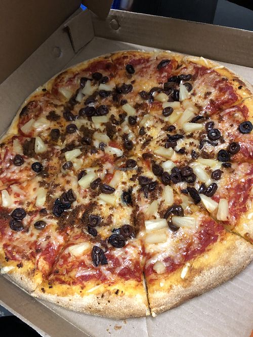 Pizza with Violife cheese, plant-based chorizo, black olives, and pineapple   at Pizza Pizza in Toronto