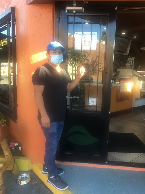 Manager Hector with HappyCow window decal at The Grain Cafe in Van Nuys