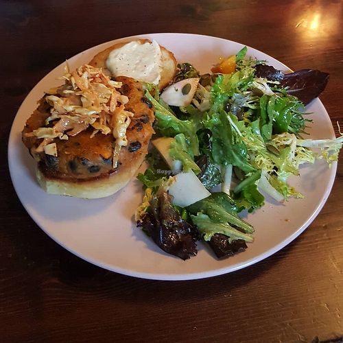 The quite possible burger: scratch-made sweet potato patty on a house bun piled up with chipotle peanut slaw, caramelized onion “aioli”, fried shallots, micros. served with a s at Ollie in Ypsilanti