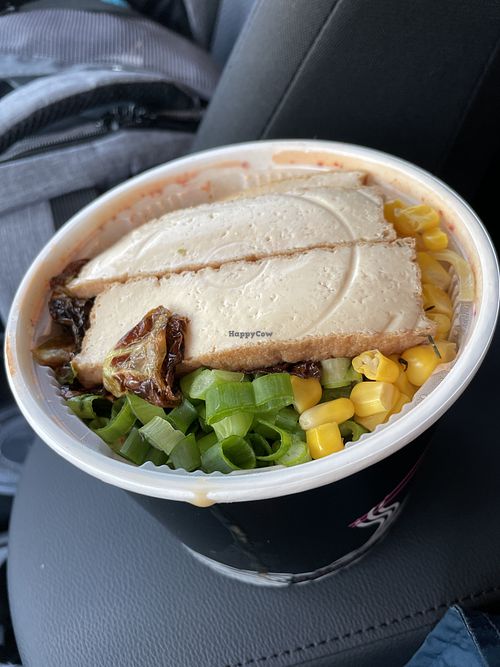 Cup of ingredients ready to be added to the broth underneath.  at Kotsu Ramen & Gyoza in Montclair