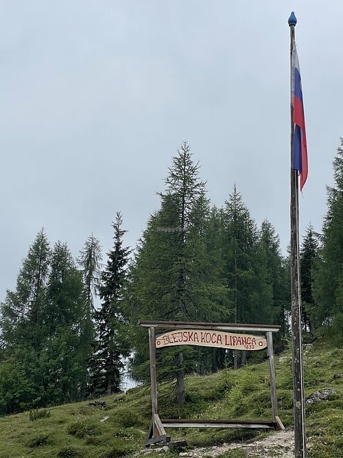 Welcome sign and Slovenian flag.  at Krekova koča na Ratitovcu in Torka