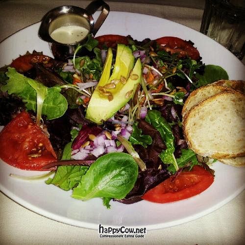 Baby greens salad w/ tomato, sprouts, sunflower seeds, carrot, red onion & avocado - vegan creamy garlic dressing and homemade bread.  at Adama in Santa Barbara
