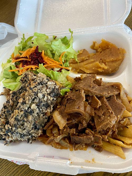 Medium plate with black bean loaf, onion ‘steak’, salad, pasta, and pumpkin.  at Eden's Vegan Eatery in St Croix