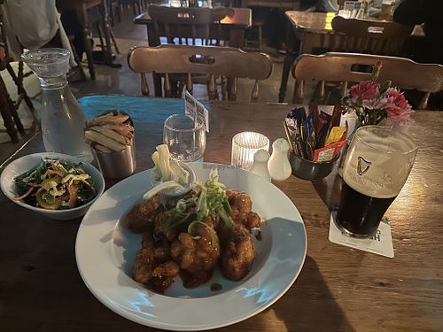 Vegan cauliflower wings with chips, a side salad, and a pint of Guinness    at Dolan's Pub and Restaurant in Limerick