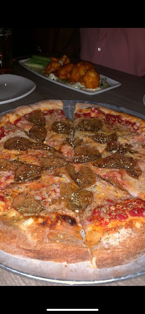 Vegan Pepperoni Pizza with Buffalo Cauliflower wings in the background at Mohawk Bend in Los Angeles