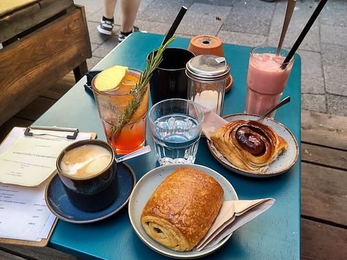 Pain au chocolat, cinnamon roll, flat white, blood orange lemonade, pink velvet latte on ice at Cafe Lozzi in Munich