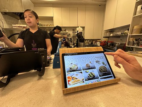 Digital menu on the counter and the small kitchen set up   at Mana Café in Manama
