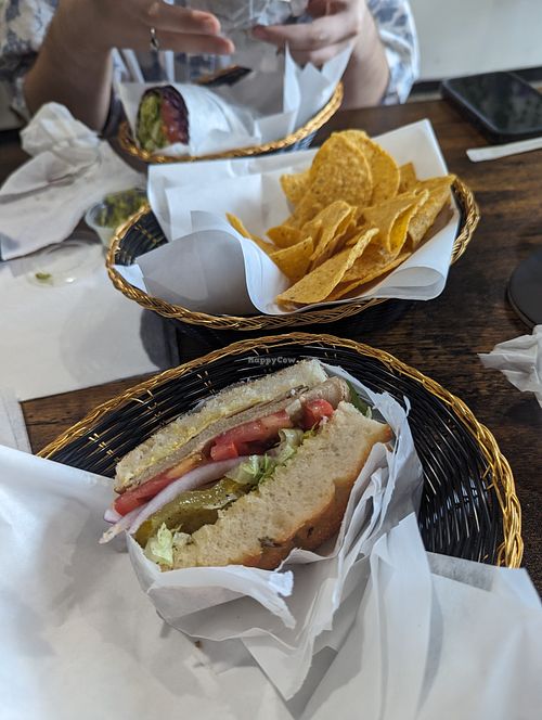 Foreground: build your own sandwich + turky with red onions, lettuce, tomatoes, pickles on rosemary foccacia. Background: chickpea curry in a nori wrap.  at Royal Health World Retail & Cafe in Atlanta