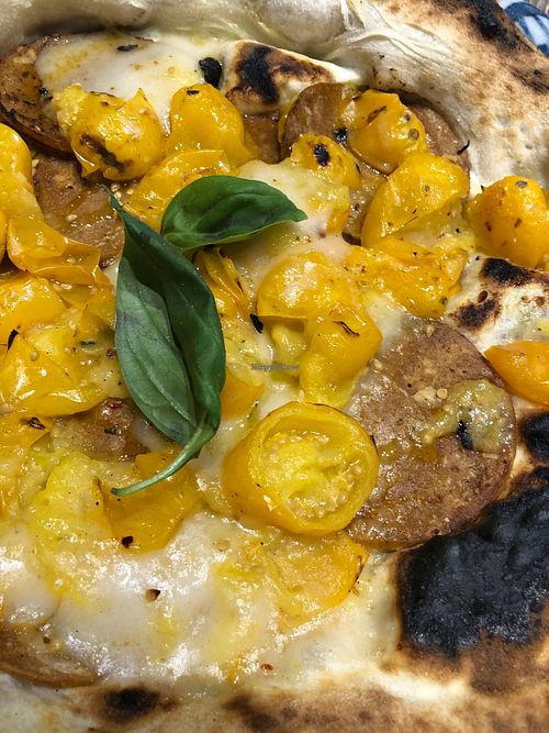 Pizza with vegan pepperoni, rice mozzarella, and yellow cherry tomatoes  at Assaje in Turin