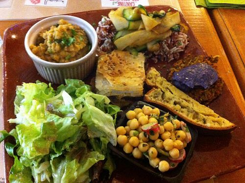 composed plates with different delicious food : cake, vegetables pancakes with beet emulsion, chickpeas, greens, brown rice, lentil puree. Everything vegan at Mariposas in Marseille