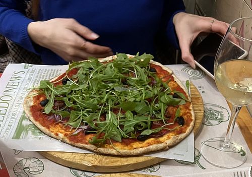 Pizza con tomate seco, cebolla roja, aceitunas y rúcula   at Pizzería Comes in Toledo