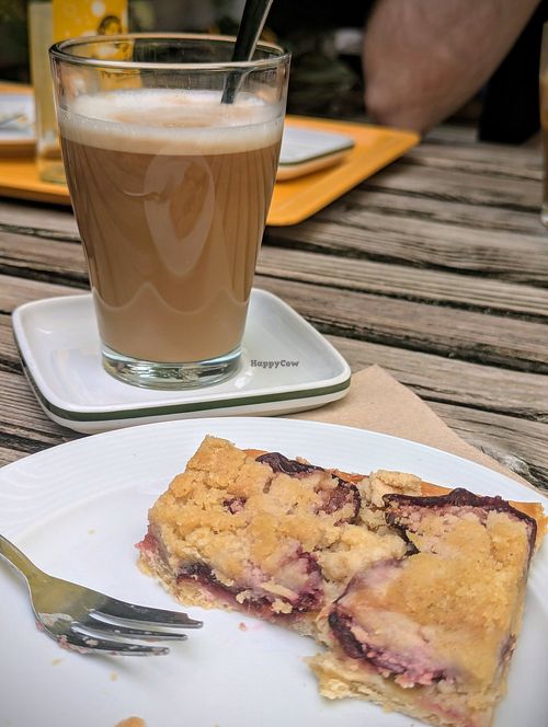 Veganer Pflaumen-Streuselkuchen und Latte Macchiato mit Hafermilch 👍🏻 at Café Helfensteine in Zierenberg