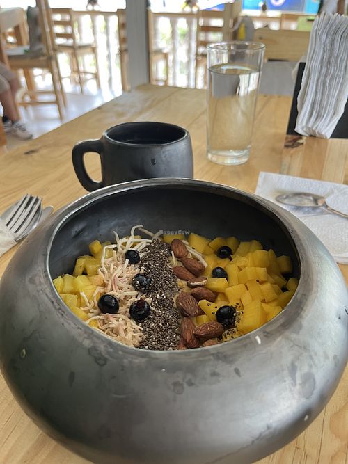 Mango frappe made with coconut milk covered with fresh mango, pineapple, chia seeds, almonds, coconut, and berries  at Romero in Huatulco